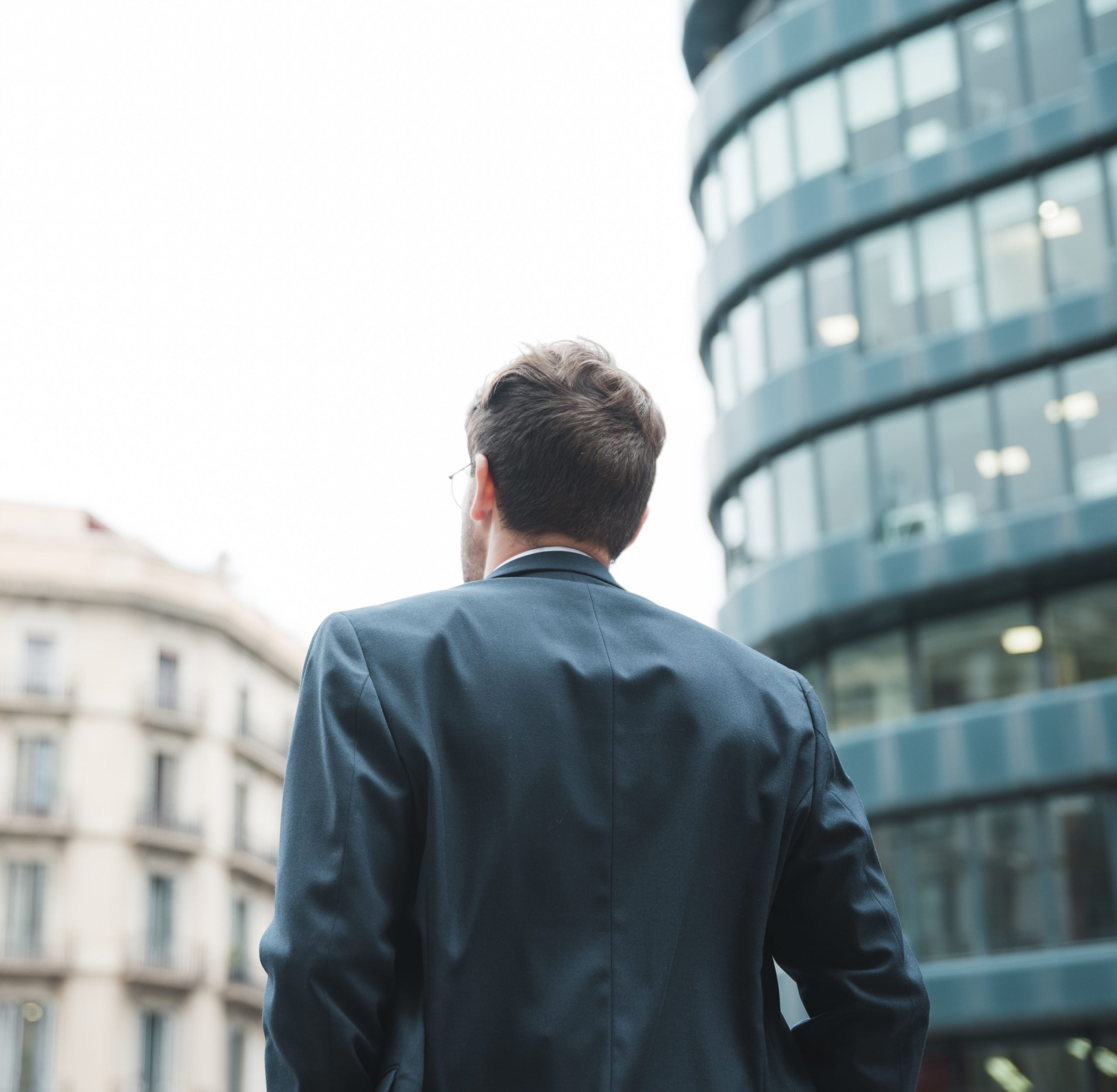 rear-view-businessman-looking-corporate-building-city